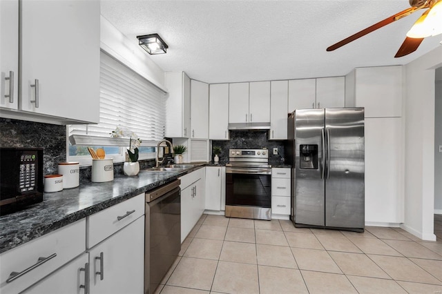 kitchen with light tile patterned floors, a textured ceiling, white cabinetry, sink, and stainless steel appliances