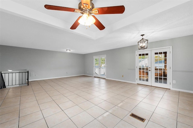 unfurnished room featuring french doors, light tile patterned flooring, and ceiling fan with notable chandelier