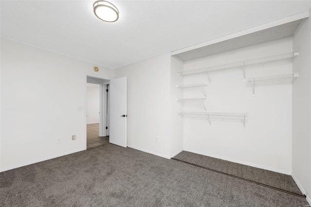 unfurnished bedroom featuring a textured ceiling, carpet flooring, and a closet