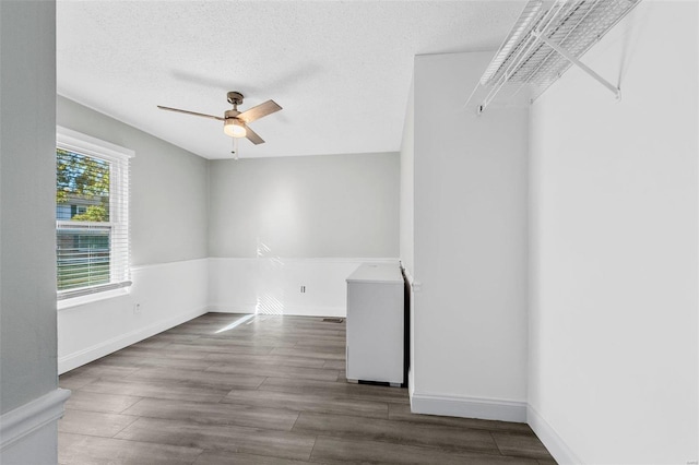 unfurnished room featuring ceiling fan, a textured ceiling, washer / clothes dryer, and hardwood / wood-style floors