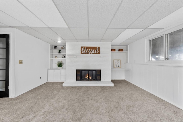 unfurnished living room with built in features, carpet flooring, and a fireplace