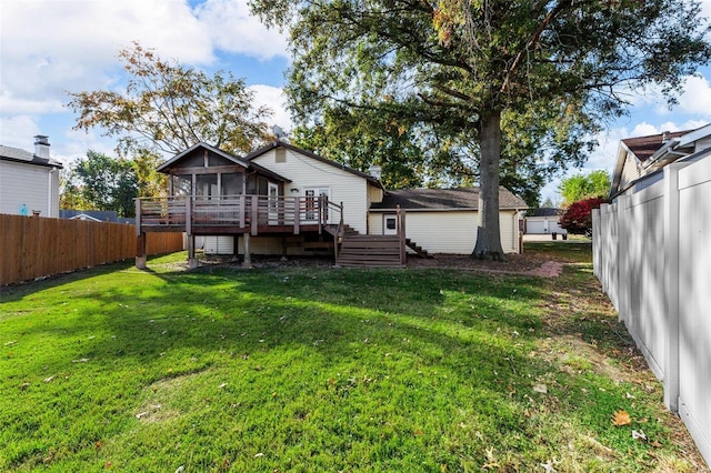 rear view of house featuring a deck and a lawn