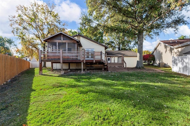 rear view of property with a wooden deck, a lawn, and a sunroom