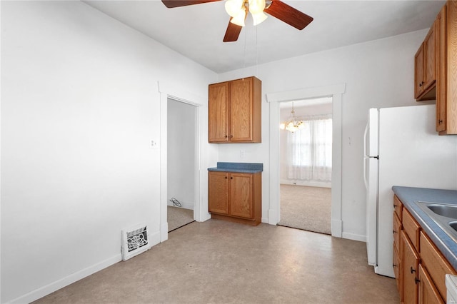 kitchen featuring ceiling fan with notable chandelier and white fridge