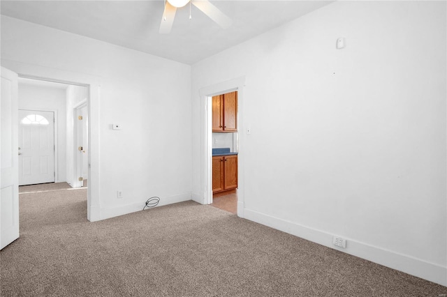 spare room featuring light colored carpet and ceiling fan