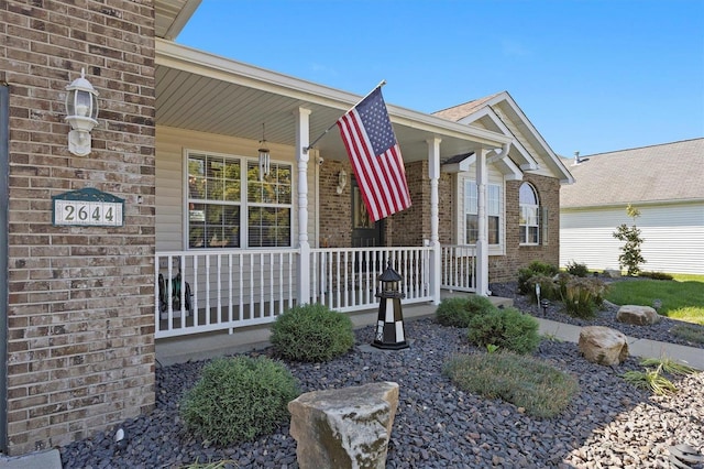 view of exterior entry featuring covered porch