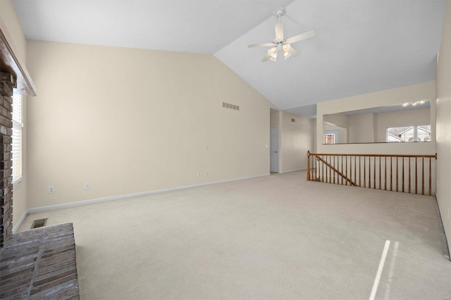 unfurnished living room with plenty of natural light, ceiling fan, a fireplace, and light carpet