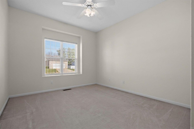 carpeted spare room with ceiling fan