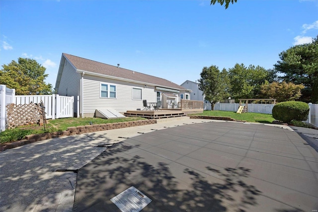 back of property with a yard, a playground, a deck, and a patio area