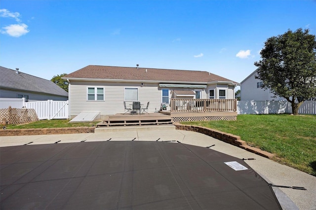 rear view of property with a lawn and a wooden deck