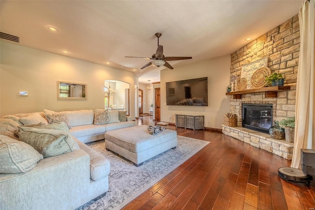 living room with a fireplace, dark hardwood / wood-style flooring, and ceiling fan