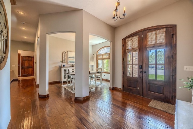 foyer entrance with a notable chandelier, french doors, and dark hardwood / wood-style flooring