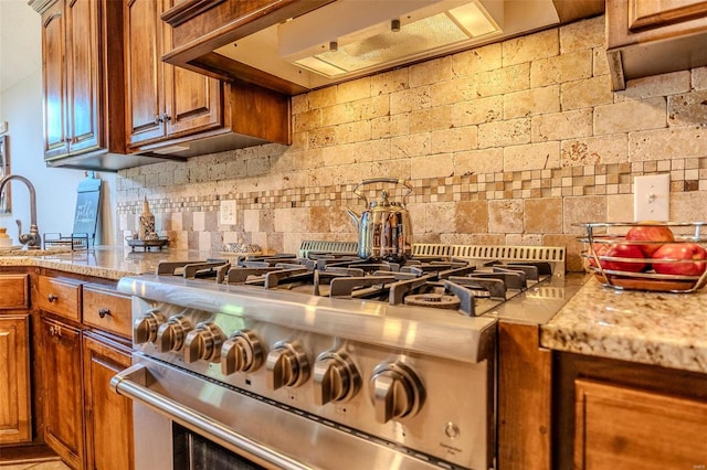 kitchen with decorative backsplash, high end range, premium range hood, and light stone counters