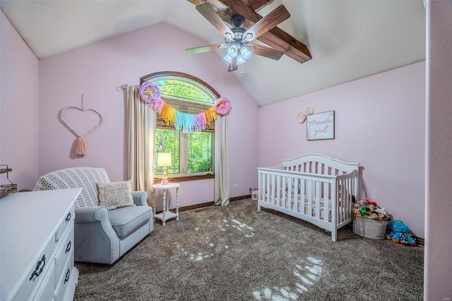 bedroom featuring lofted ceiling, dark colored carpet, ceiling fan, and a nursery area