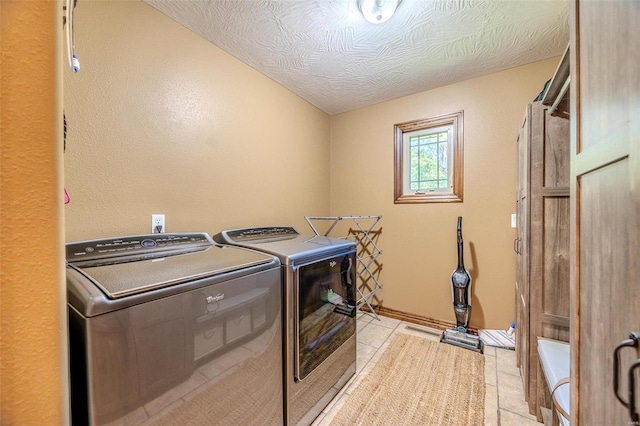 laundry area with light tile patterned flooring, independent washer and dryer, and a textured ceiling