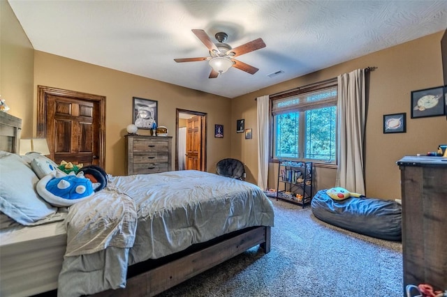 bedroom with ceiling fan, a textured ceiling, and carpet flooring