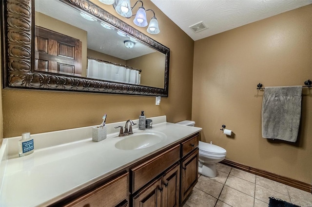 bathroom featuring tile patterned floors, a textured ceiling, vanity, and toilet