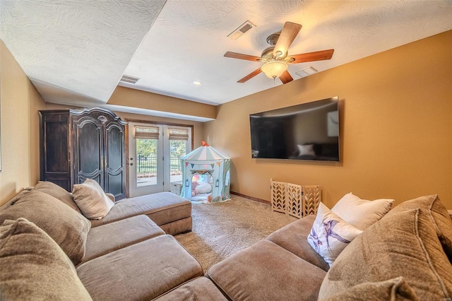 carpeted living room featuring a textured ceiling and ceiling fan