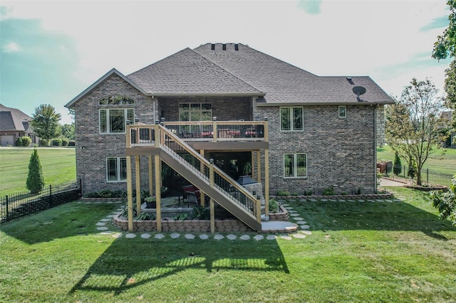 rear view of house featuring a lawn and a deck