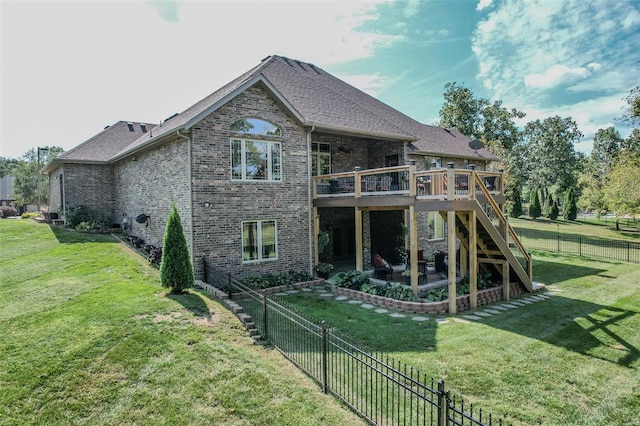 rear view of house featuring a wooden deck and a yard