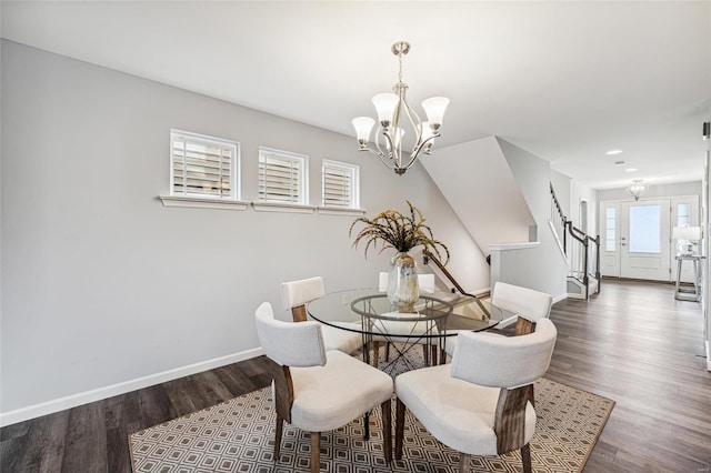 dining space with dark hardwood / wood-style flooring and a chandelier