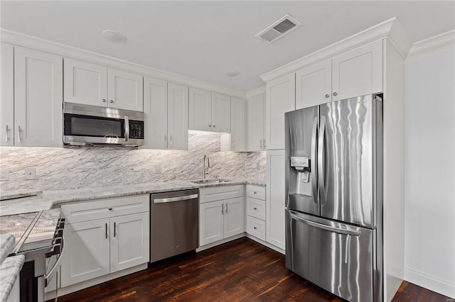 kitchen with white cabinetry, dark wood-type flooring, stainless steel appliances, ornamental molding, and sink