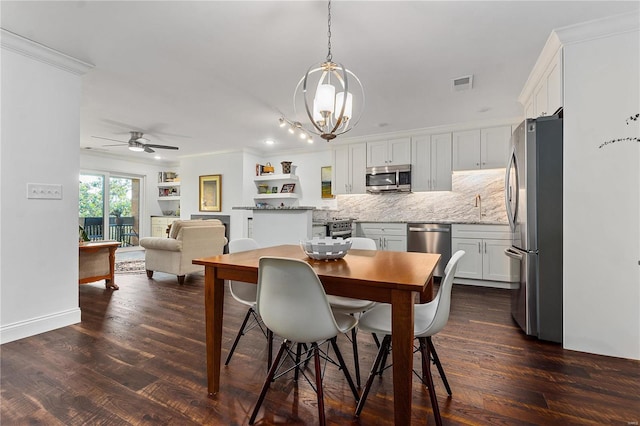 dining room with ceiling fan with notable chandelier, ornamental molding, dark wood-type flooring, and sink