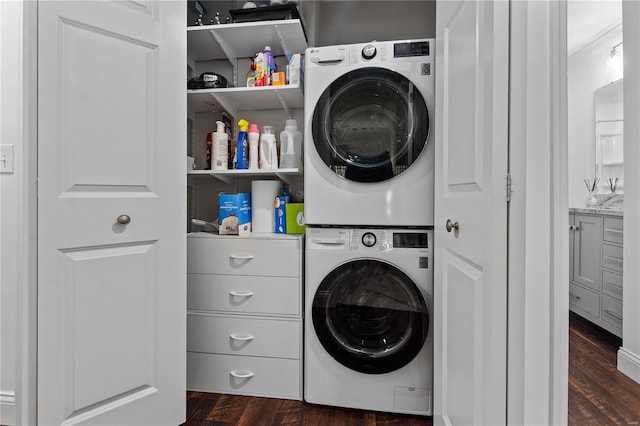 clothes washing area with stacked washer and dryer and dark hardwood / wood-style flooring