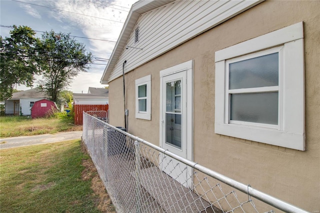 view of side of home featuring a yard and a shed