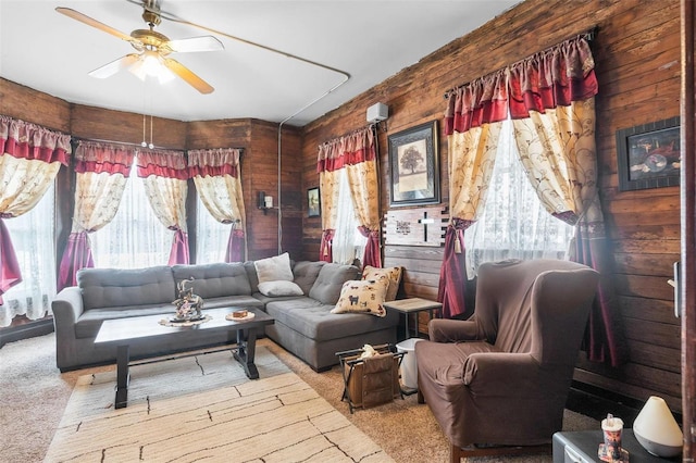 living room with ceiling fan, light colored carpet, and wooden walls