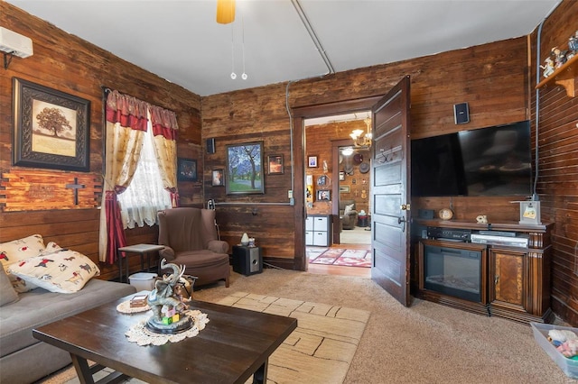 living room featuring ceiling fan, light colored carpet, wooden walls, and a wall mounted air conditioner