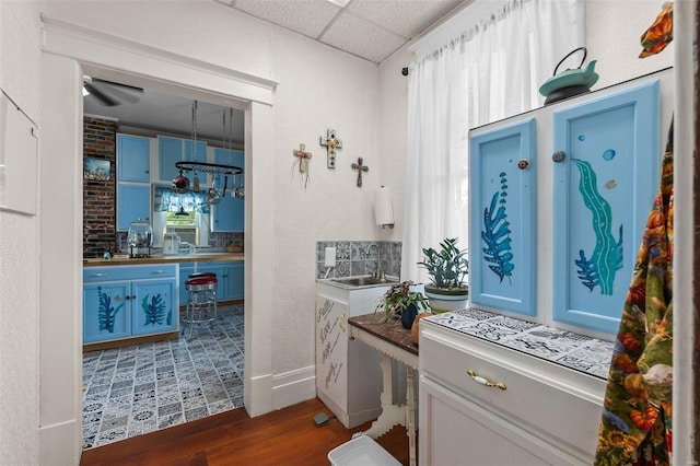 bathroom featuring wood-type flooring, ceiling fan, sink, and a paneled ceiling