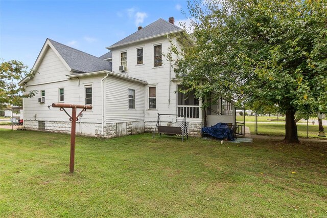 rear view of property with a yard and a sunroom