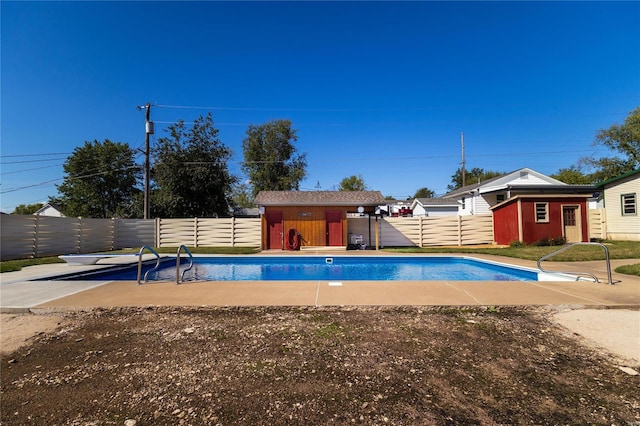 view of pool featuring a storage unit and a diving board