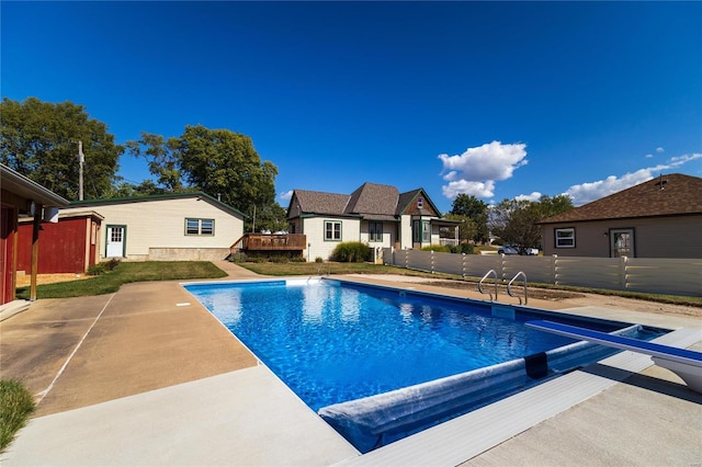 view of swimming pool featuring a patio and a diving board