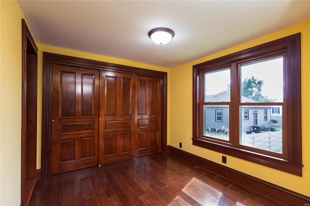 unfurnished bedroom with dark hardwood / wood-style flooring