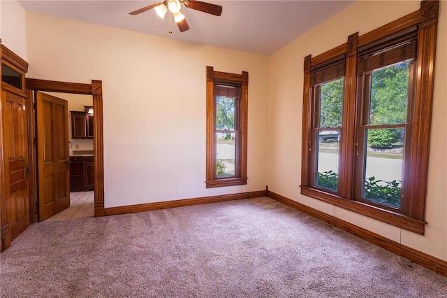 empty room featuring ceiling fan and light colored carpet