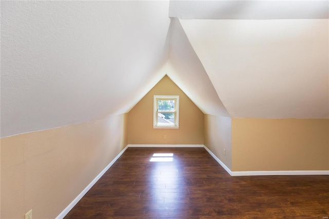 bonus room featuring lofted ceiling and dark hardwood / wood-style flooring