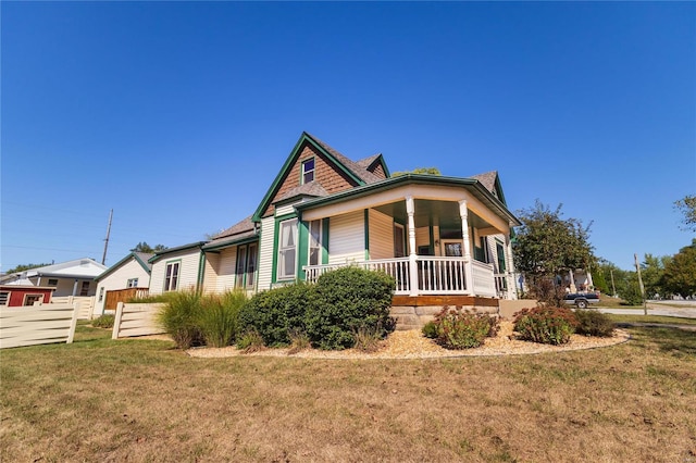 view of front of property featuring covered porch and a front yard