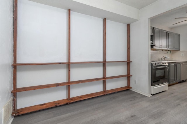 basement with sink and light hardwood / wood-style flooring