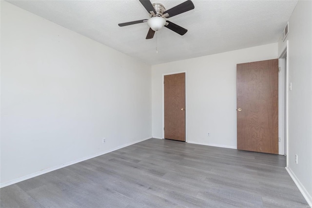 spare room with hardwood / wood-style floors, a textured ceiling, and ceiling fan