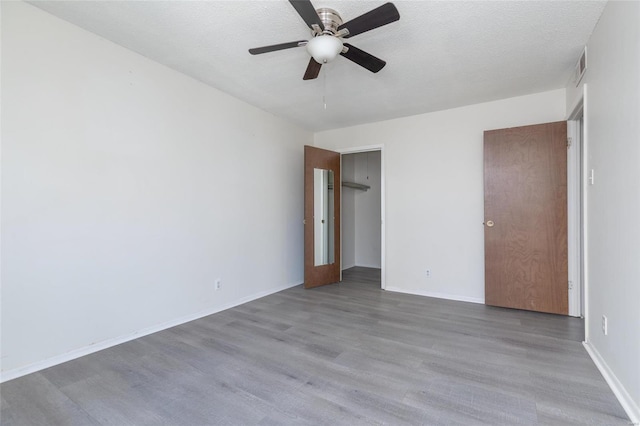 spare room with wood-type flooring, ceiling fan, and a textured ceiling