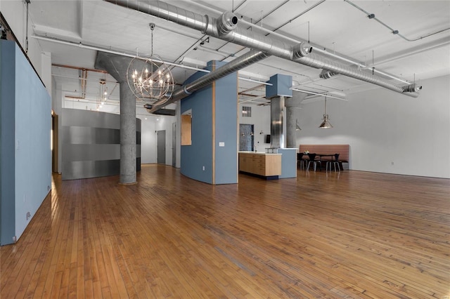 interior space with wood-type flooring and an inviting chandelier