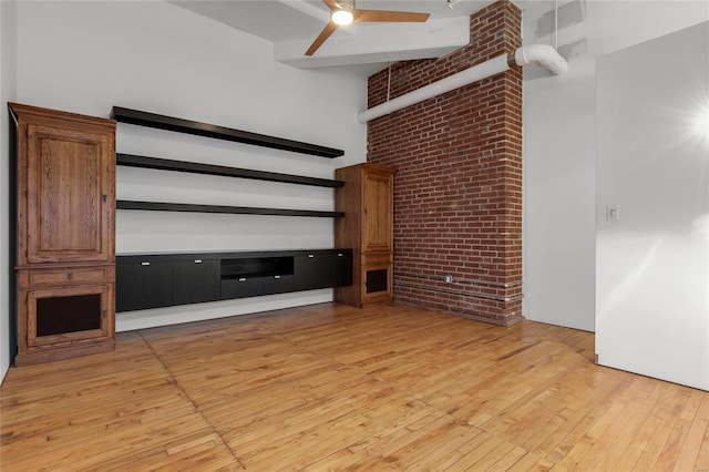 unfurnished living room with a high ceiling, beamed ceiling, ceiling fan, and light hardwood / wood-style flooring