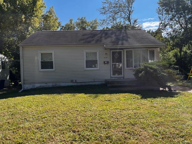 view of front of home featuring a front lawn and a sunroom