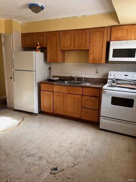 kitchen with tasteful backsplash, sink, and white appliances