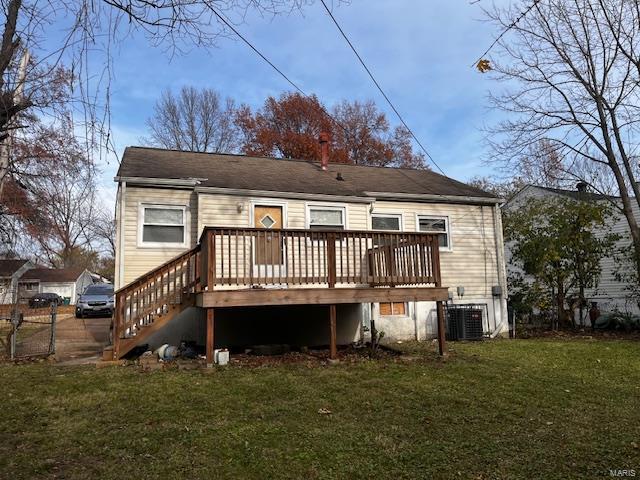 rear view of house with a lawn, a wooden deck, and central AC unit