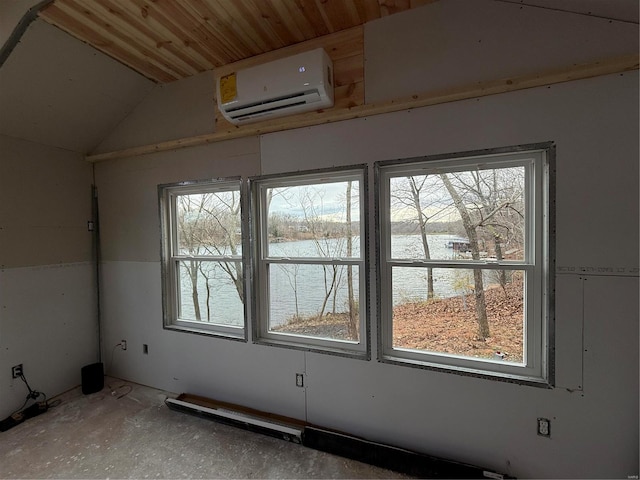 empty room with a healthy amount of sunlight, a water view, a wall mounted AC, and lofted ceiling