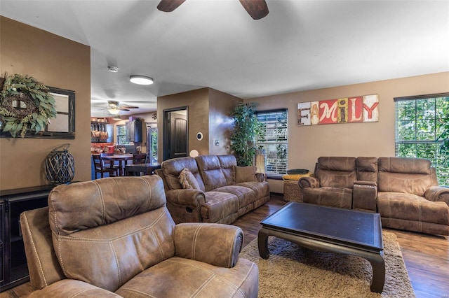 living room featuring wood-type flooring and ceiling fan