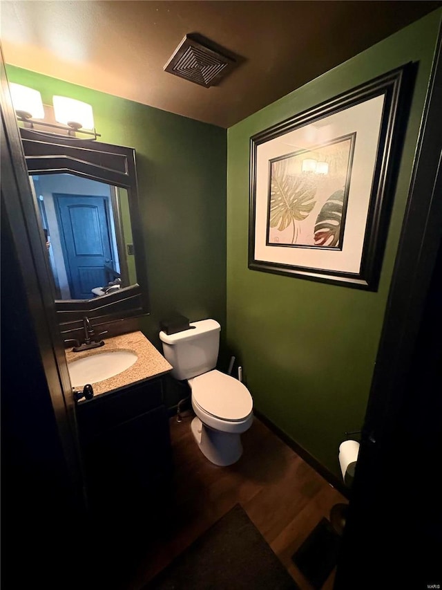 bathroom featuring vanity, toilet, and wood-type flooring